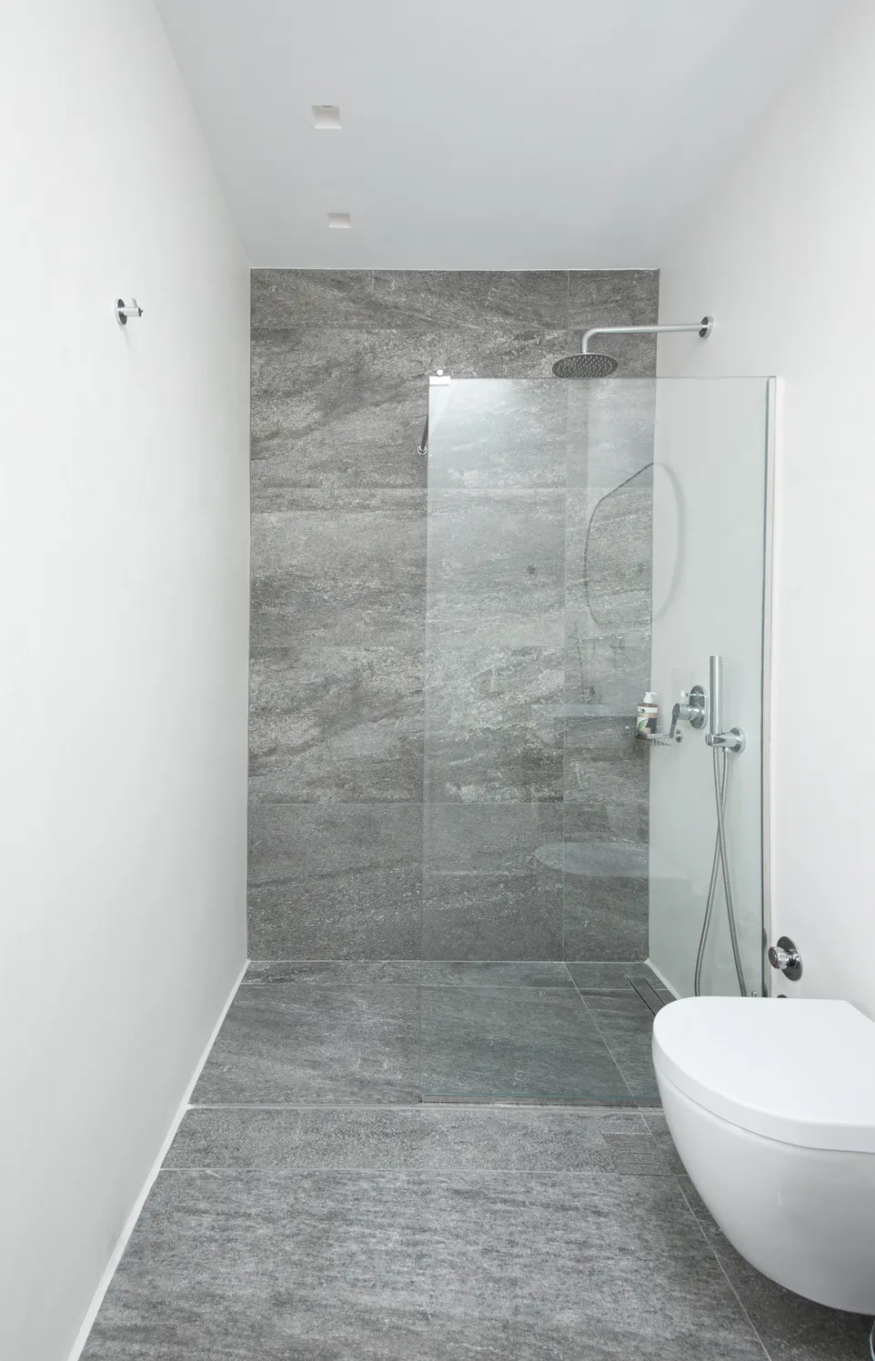 Walk-in shower with grey stone tiles